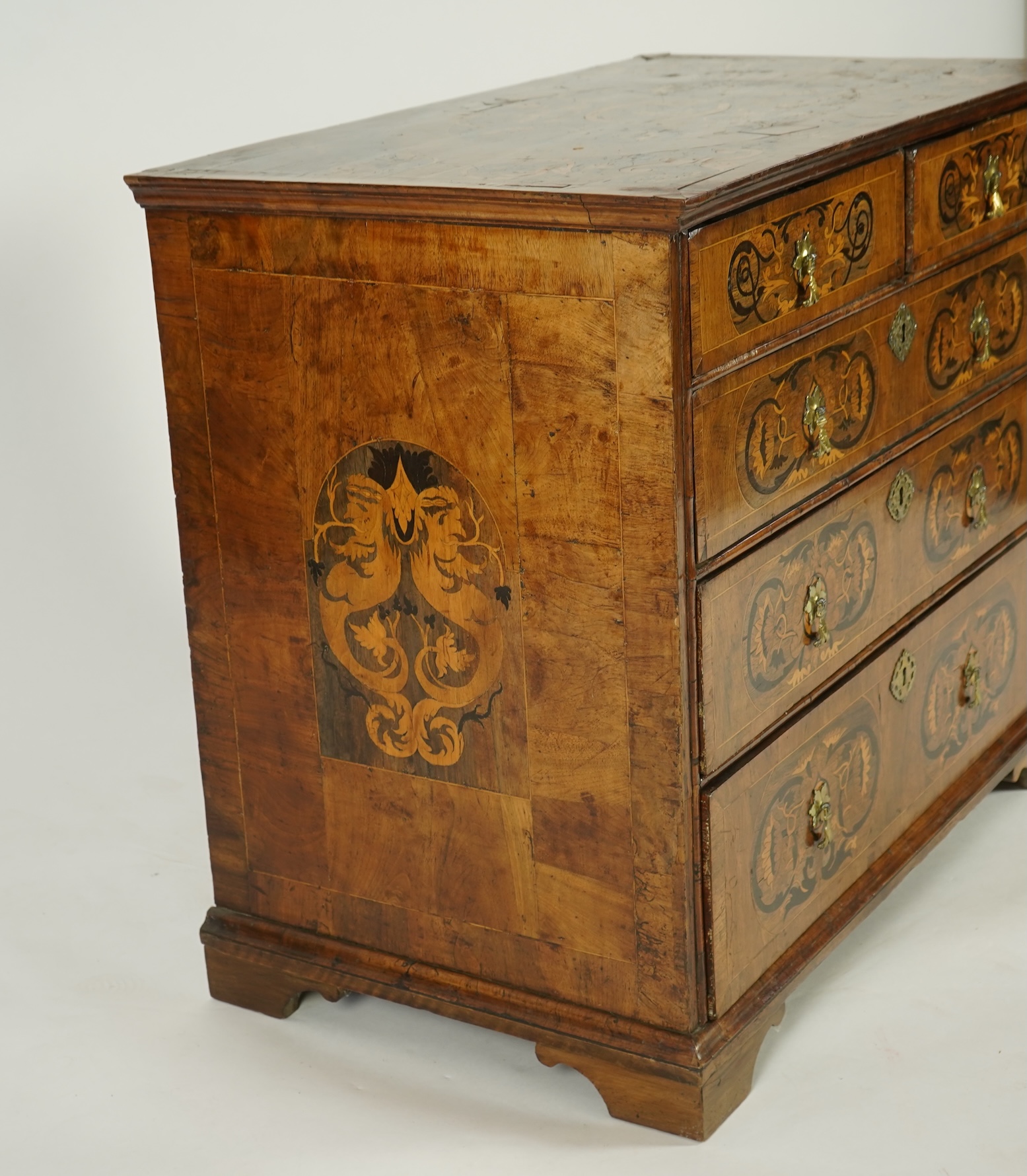 A William and Mary walnut and floral marquetry chest on later bracket feet